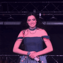 a woman in a blue dress is dancing on a stage in front of a microphone .