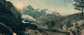 a train traveling through a mountainous landscape with trees and mountains in the background