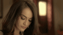 a woman with a bindi on her forehead looks down at something
