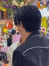 a man wearing a black shirt with the letter m on the back is standing next to another man