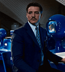 a man in a suit and tie is sitting in front of a blue sphere with a reflection of a person in it