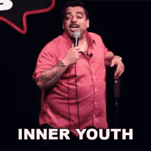 a man in a red shirt is holding a microphone with the words inner youth written below him