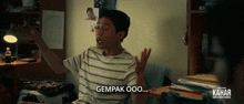 a man in a striped shirt is making a gesture with the words gempak ooo