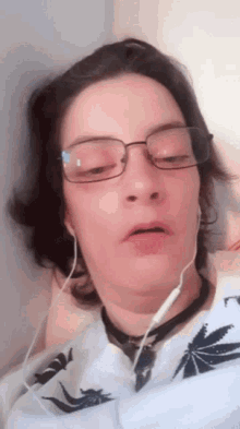 a woman wearing glasses and headphones looks at the camera