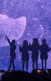 a group of people standing in front of a purple background