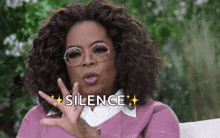 oprah winfrey is wearing glasses and making a silence sign