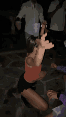 a woman holds a cup over her head while a man holds her arm