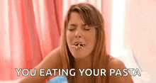 a woman is eating pasta with her eyes closed and the words `` you eating your pasta '' written next to her .