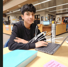 a boy sits at a desk with a laptop and a pink sign that says to maximize finishing classes