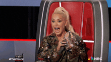 a woman is sitting in a chair with a nbc logo on the back