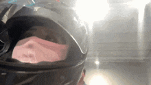 a person wearing a black helmet with a pink mask on