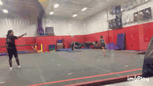 a gif of a girl doing a trick in a gym