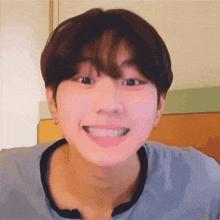 a young man with short hair and bangs is smiling for the camera