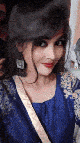 a woman in a blue dress is taking a selfie with her phone