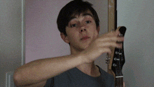 a man covering his face while holding a guitar with the words bah je te l' accorde behind him