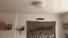 a sign that says it 's a hockey night in pittsburgh hangs on a wall