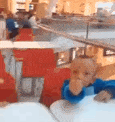 a baby is sitting at a table in a restaurant eating a sandwich .