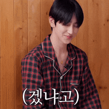 a young man wearing a plaid shirt with korean writing on it