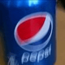 a can of pepsi is sitting on a table .