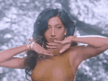 a woman with blue hair is wearing a yellow top and earrings