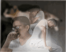 a man wearing glasses is sitting on another man 's lap