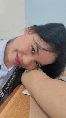 a woman laying on a wooden table with a black strap that says " believe " on it