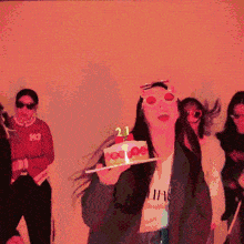 a woman is holding a cake with candles that say 21