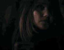 a close up of a woman 's face in the dark looking at the camera .