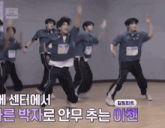 a group of young men are dancing in a room with chinese writing