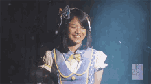 a girl in a blue and white outfit with the number 48 on the bottom right
