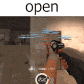 a person holding a gun in front of a wall with the word open above them