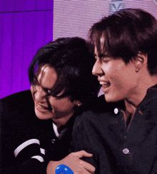 two men are hugging each other and one of them is laughing