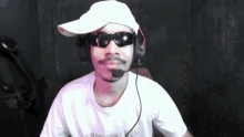 a man wearing a white hat and sunglasses with a microphone