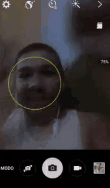 a phone screen shows a man with a circle around his face