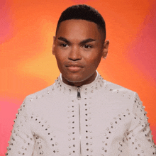 a young man in a white jacket with studs on it