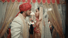 a bride and groom are standing under a canopy looking at each other