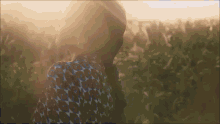 a woman standing in a field with the sun shining on her face