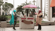 a man in a hot dog costume stands next to a hot dog stand