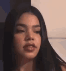 a close up of a woman with long hair making a funny face .