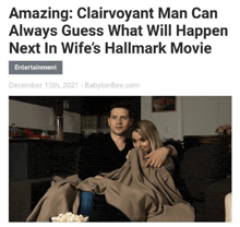 a man and a woman are sitting on a couch watching a hallmark movie with popcorn