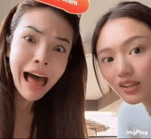 two women are standing next to each other with their mouths open and one of them is wearing a mask .