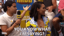a man holding a microphone says " you know what i 'm saying " next to a woman