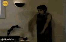 a woman is dancing in a room with a sign that says viva