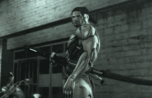 a man in a futuristic suit is holding a gun and has a tattoo on his arm