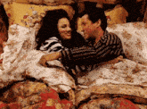 a man and a woman are hugging in a bed