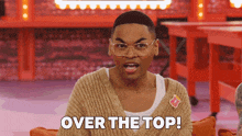 a man wearing glasses and a tan sweater says over the top