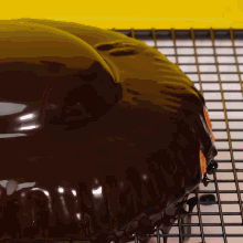 a close up of a chocolate covered donut on a cooling rack