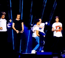 a group of people are standing on a stage and one of them has a red star on their shirt