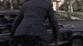 a man in a suit is opening the door of a car