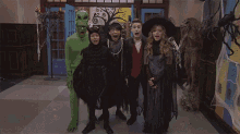 a group of people dressed up in halloween costumes are standing in a hallway